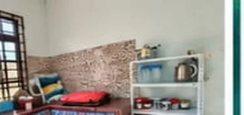Homestay kitchen with a refrigerator and cooking utensils